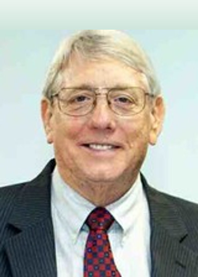 Portrait of W. Fred Eddinger, founder and CEO of Eddinger's Pest Control, smiling in a suit and tie