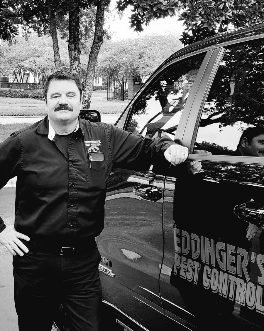David Raleigh of Eddinger's Pest Control standing beside an Eddinger's service vehicle